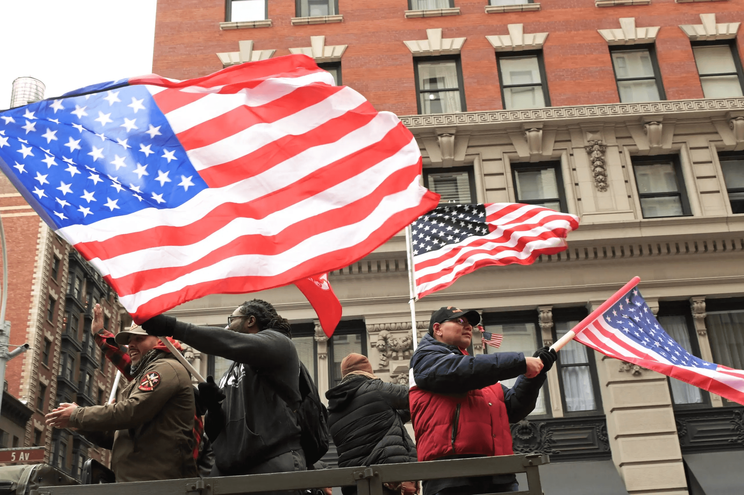Participants wave American flags along Fifth Avenue during the 2025 NYC Veterans Day Parade